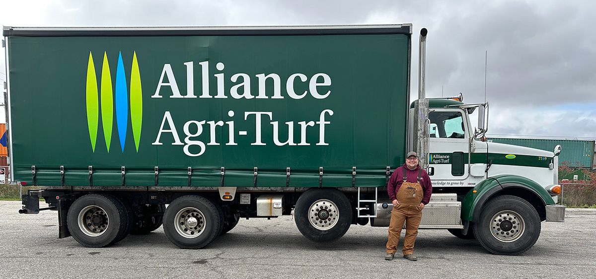 Alliance Agri-Turf team member posing by truck